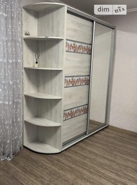 Шафа-купе з дзеркальними дверима та відкритими полицями біля стіни