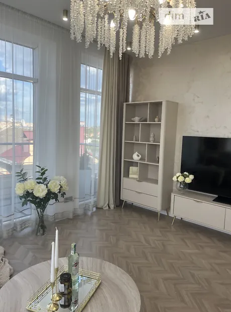 Вітальня з телевізором, стелажем та декоративною люстрою