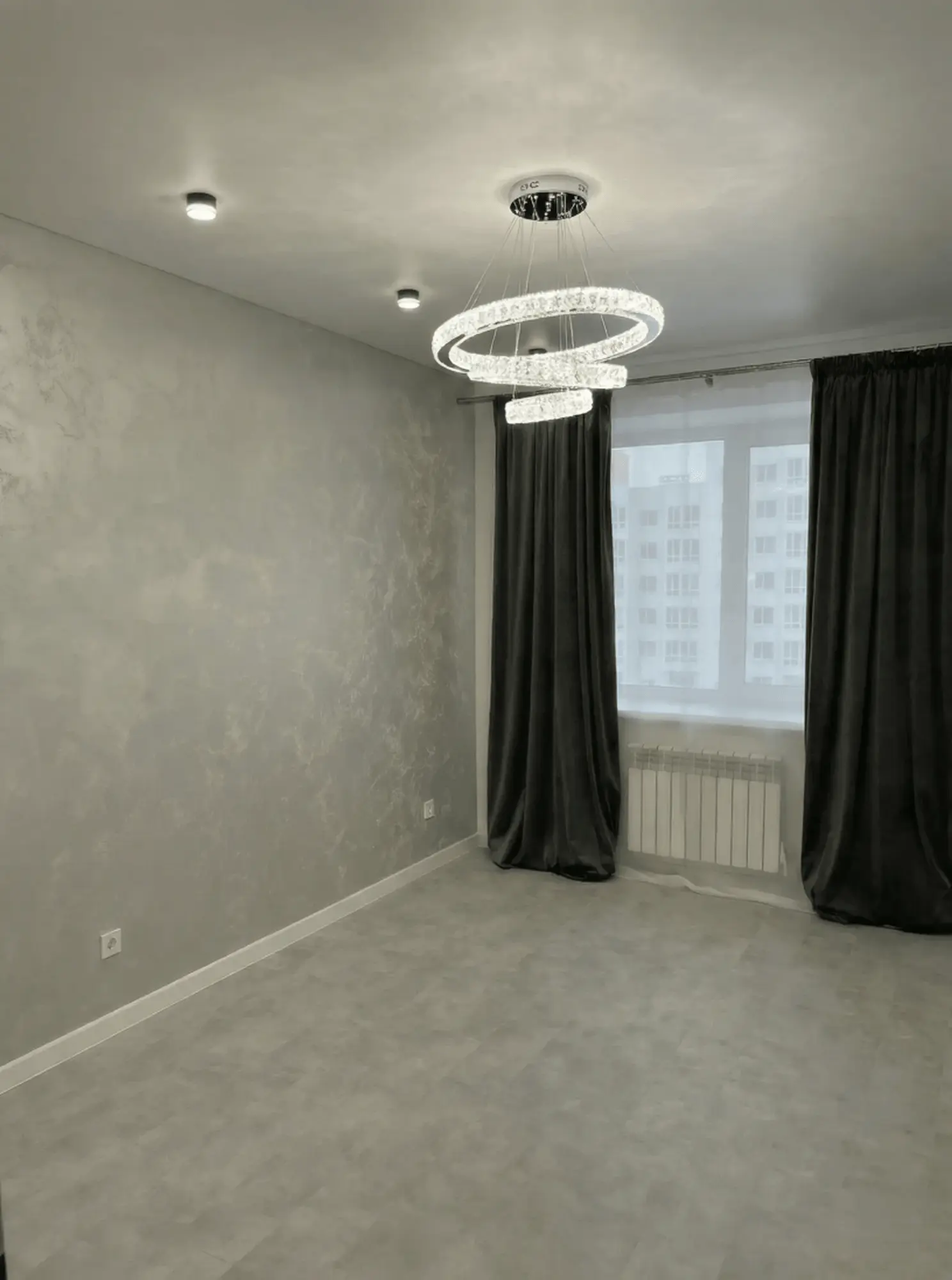 Простора світла кімната з дизайнерською люстрою